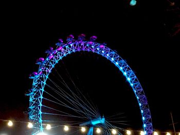 Low angle view of illuminated ferris wheel at night