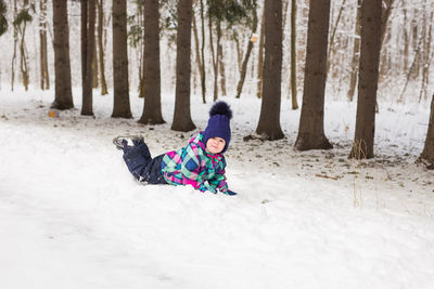 Rear view of woman skiing on snow covered field