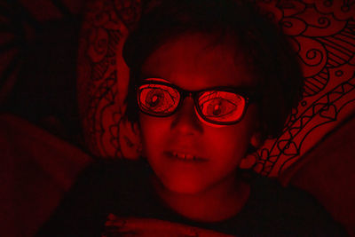 Close-up portrait of boy lying down on bed