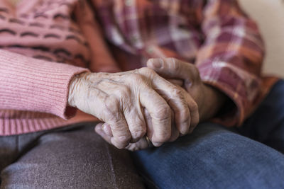 Mature man holding hands of senior woman at home