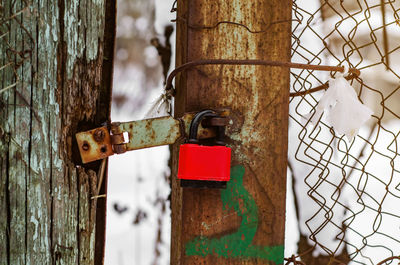 Red padlock on broken poor gate