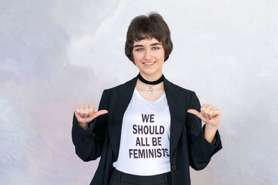 Portrait of young man standing against wall