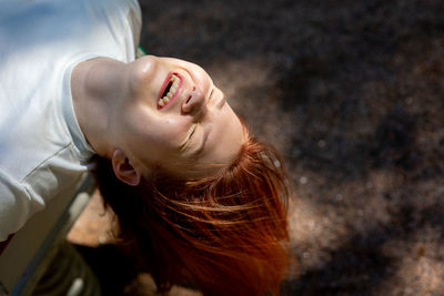 Portrait of cheerful laughing girl with long hair on background of nature