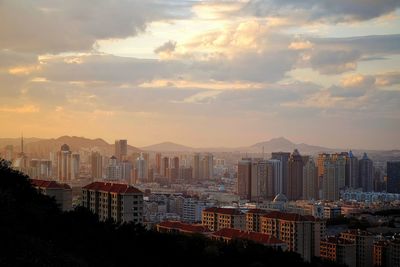 View of cityscape against cloudy sky