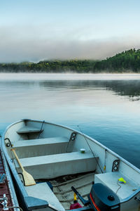 Boats moored in lake against sky