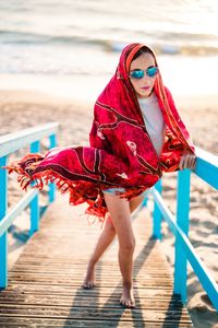 Full length portrait of woman standing by water