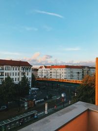 High angle view of buildings by street against sky