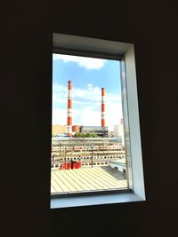 Close-up of cityscape against sky seen through window