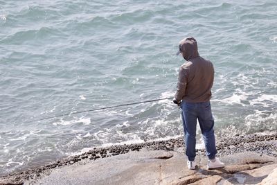 Rear view of man standing on beach