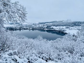 Scenic view of frozen lake against snow covered trees