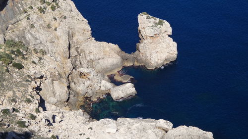 Rock formations by sea against sky