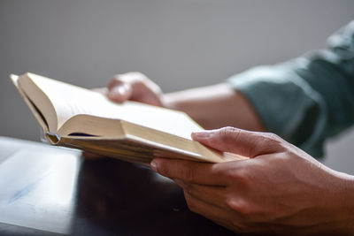 Midsection of man reading book