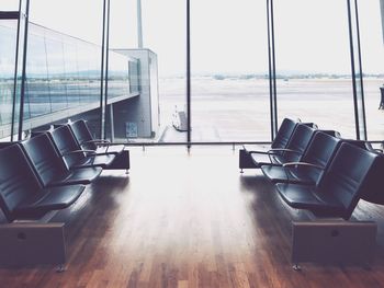 Empty chairs at airport against sky