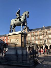 Statue in city against clear sky