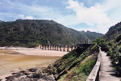 Panoramic view of dam and mountains against sky