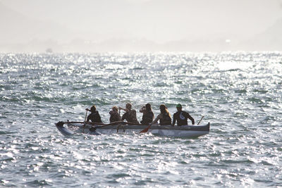 People enjoying in sea against sky