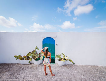 Full length of woman standing against wall