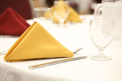 Close-up of napkin with table knife and wineglass on table
