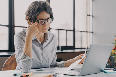 Businesswoman using laptop at office