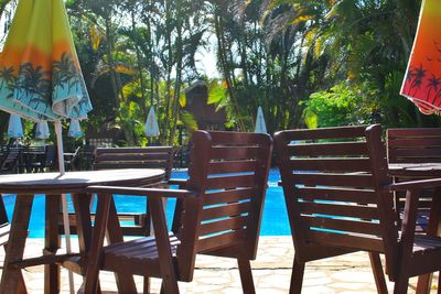 Chairs and tables by swimming pool during sunny day
