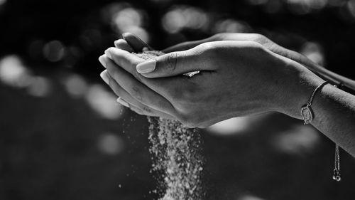 Cropped hands holding sand