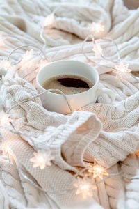 High angle view of coffee cup on bed