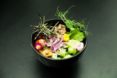 Poke salad with beef in a bowl. ingredients beef, nameko mushrooms, cherry tomatoes, rice, cucumber