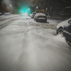Car on snow covered road at night