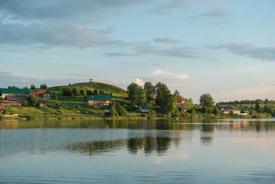 Scenic view of lake by building against sky