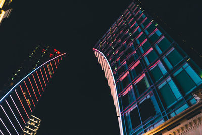 Low angle view of illuminated buildings against clear sky at night