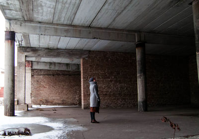 Woman standing in abandoned factory