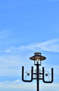 Low angle view of street light against blue sky