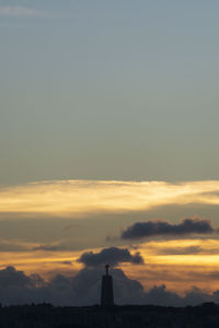 Silhouette of building against cloudy sky during sunset