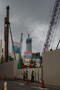 Cranes at construction site against sky