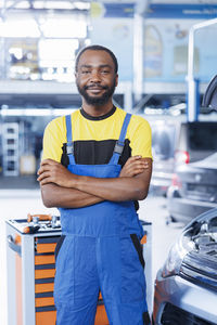 Portrait of young man standing in car