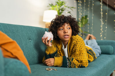 Portrait of young woman sitting on sofa at home