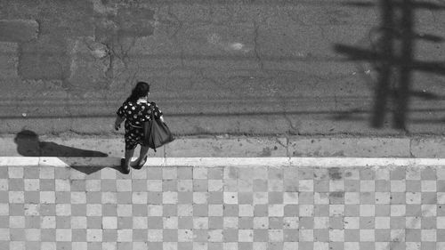 High angle view of woman standing on footpath