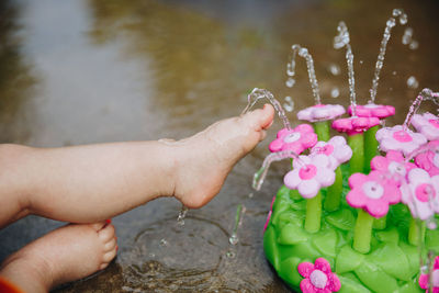 Low section of child washing feet in fountain