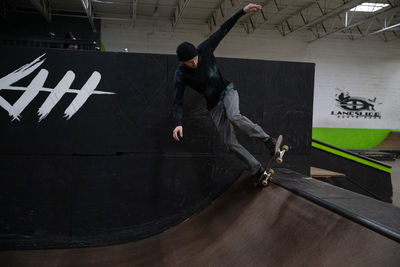 Rear view of man jumping on wall