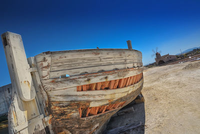 Abandoned boat against clear blue sky