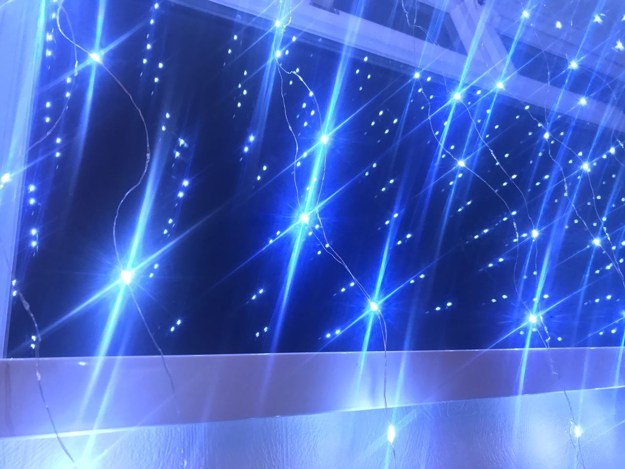 LOW ANGLE VIEW OF ILLUMINATED LIGHTS AGAINST BLUE SKY