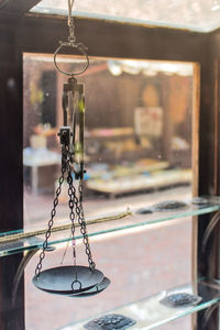 Close-up of swing hanging in glass window