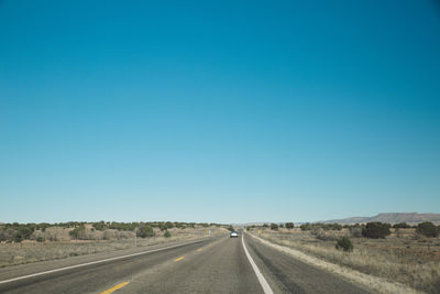Road against clear blue sky