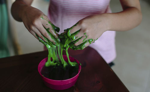 Cropped hands of girl in paint