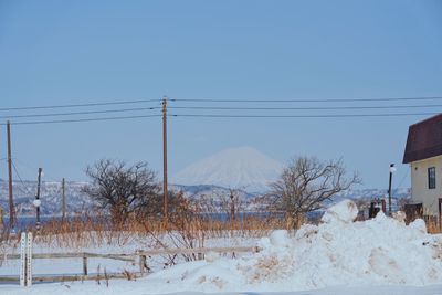 Snow covered land against clear sky