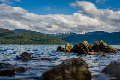 Surface level of rocks in sea against sky