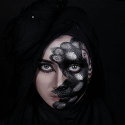 Portrait of fashion model with glitter face paint against black background