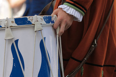 Midsection of person holding drum