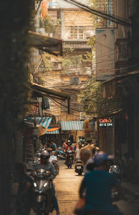 People walking on street amidst buildings in city