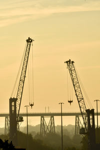 Low angle view of crane against sky during sunset